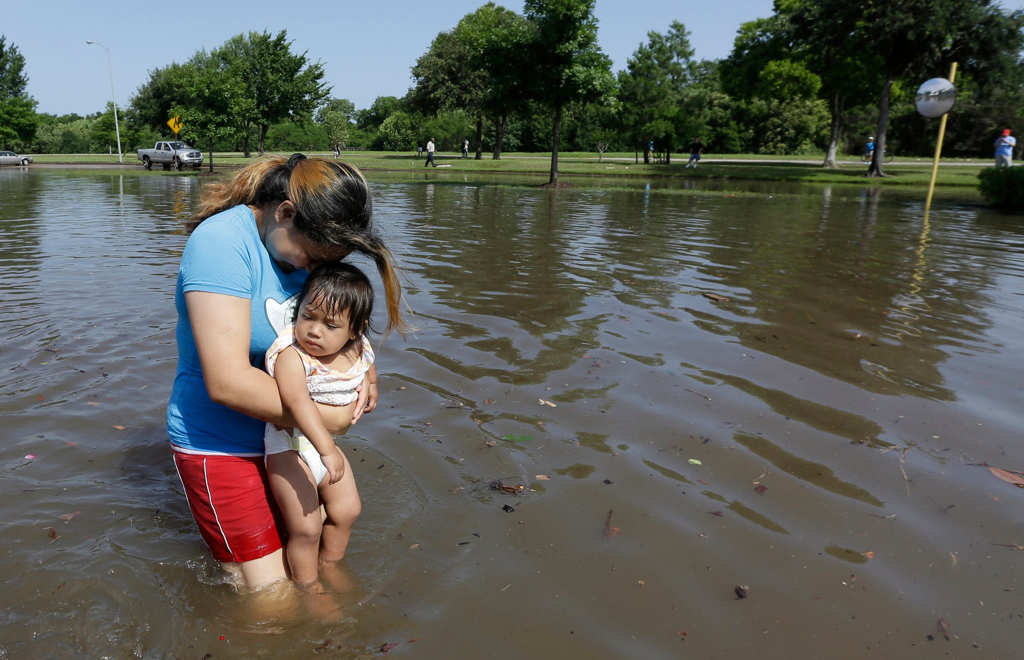 Gabby Aviles carries her daughter Audrey through floodwaters outside their apartment in Houston.
