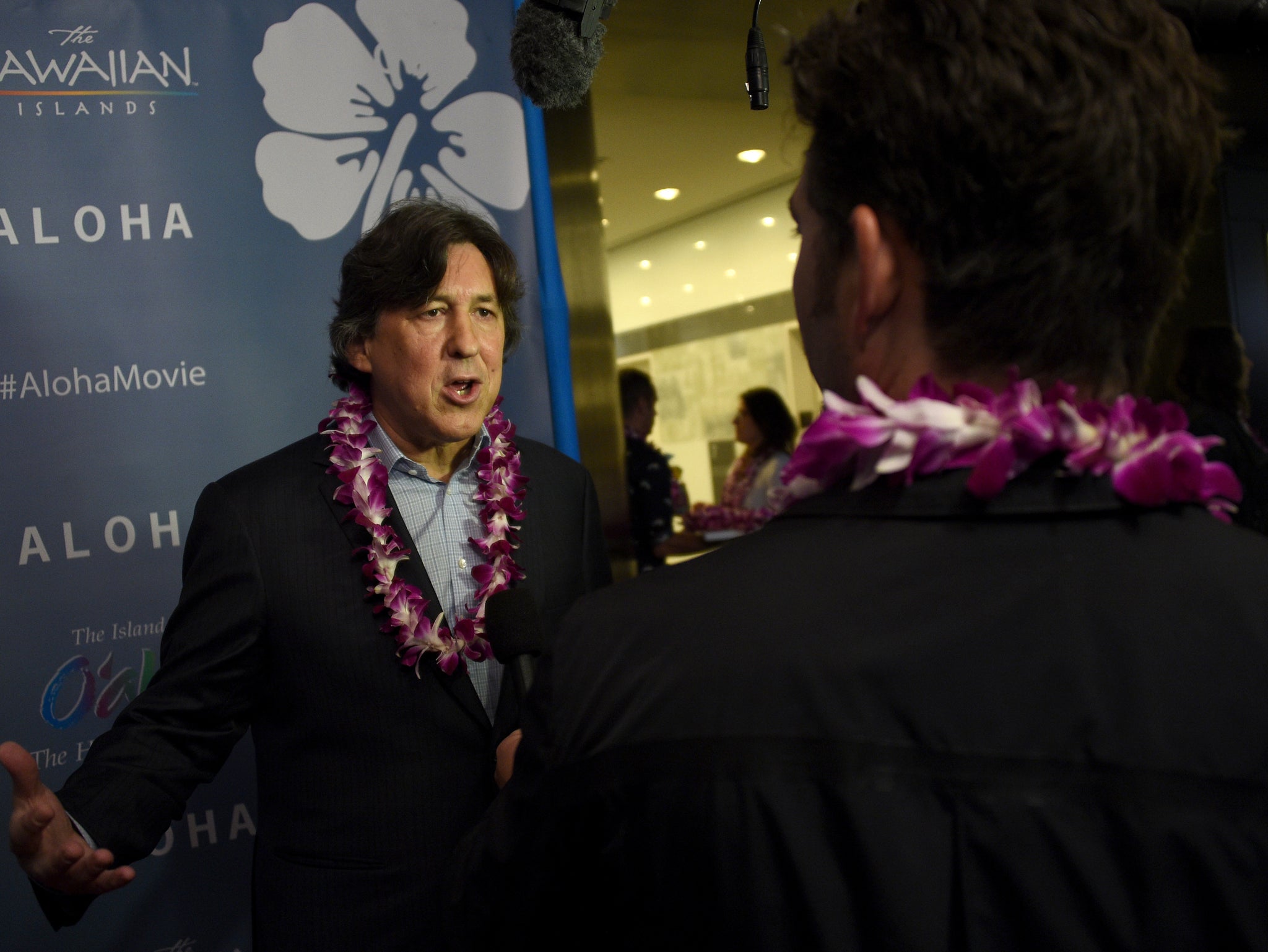 Cameron Crowe wearing floral necklaces at the Aloha premiere