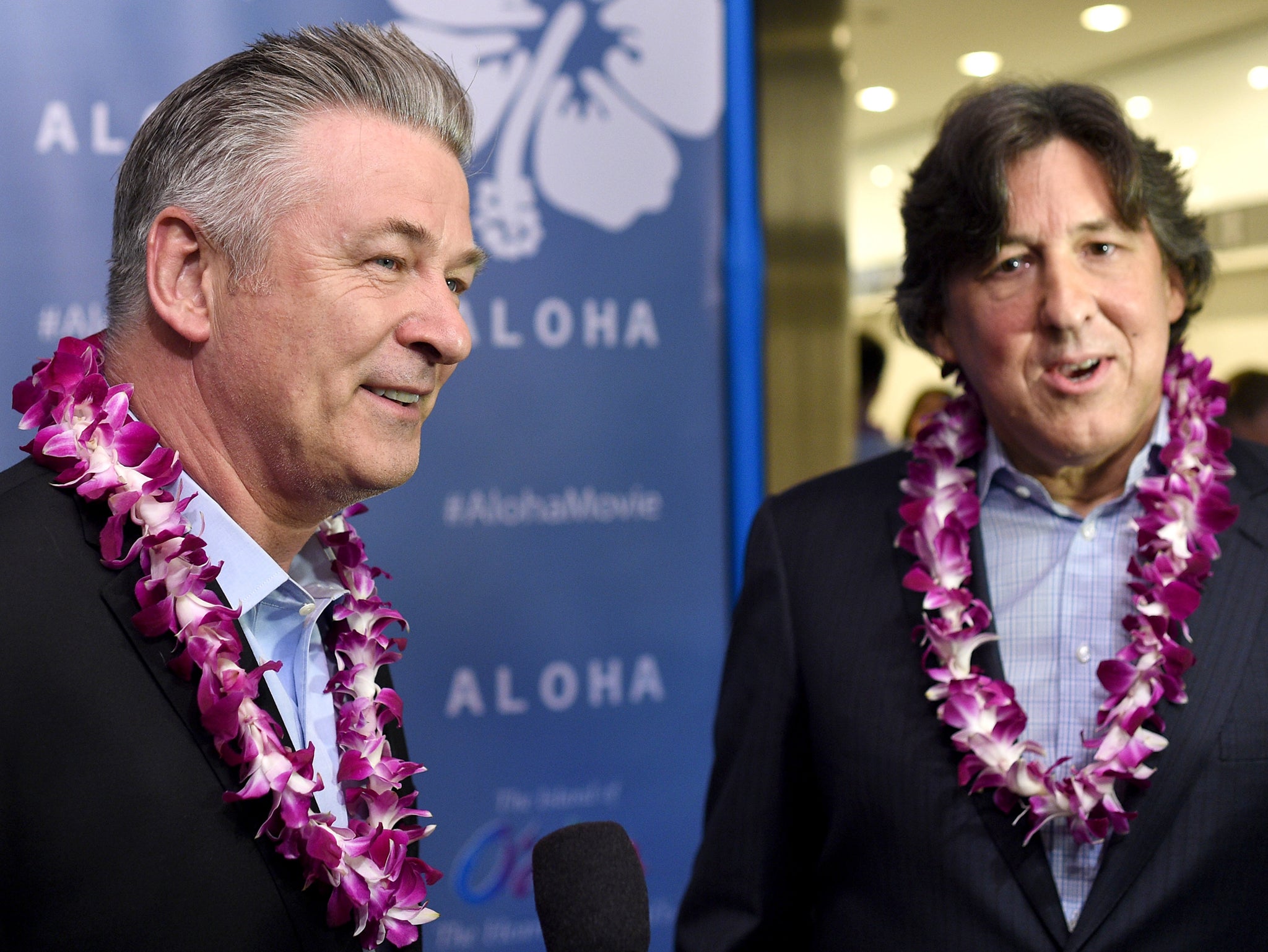 Cameron Crowe and Alec Baldwin wearing floral necklaces at the Aloha premiere