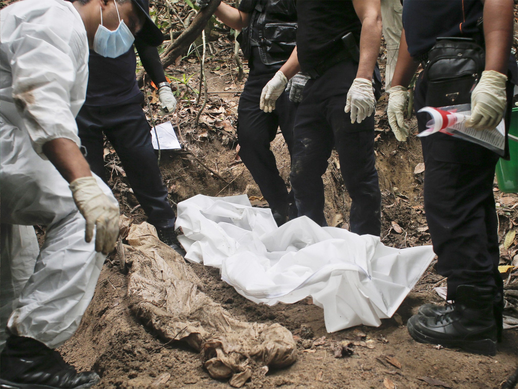 A forensic team exhumes human remains in Perlis, northern Malaysia