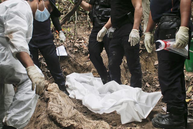 A forensic team exhumes human remains in Perlis, northern Malaysia