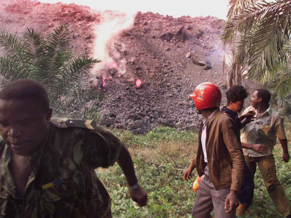 People run from a lava flow on Mount Cameroon as it erupts in 1999