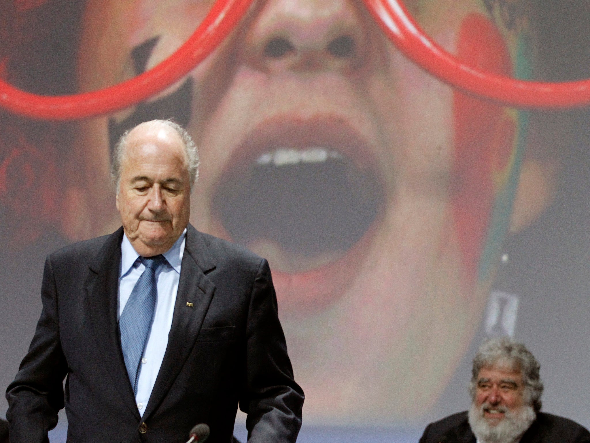 Sepp Blatter stands in front of Chuck Blazer