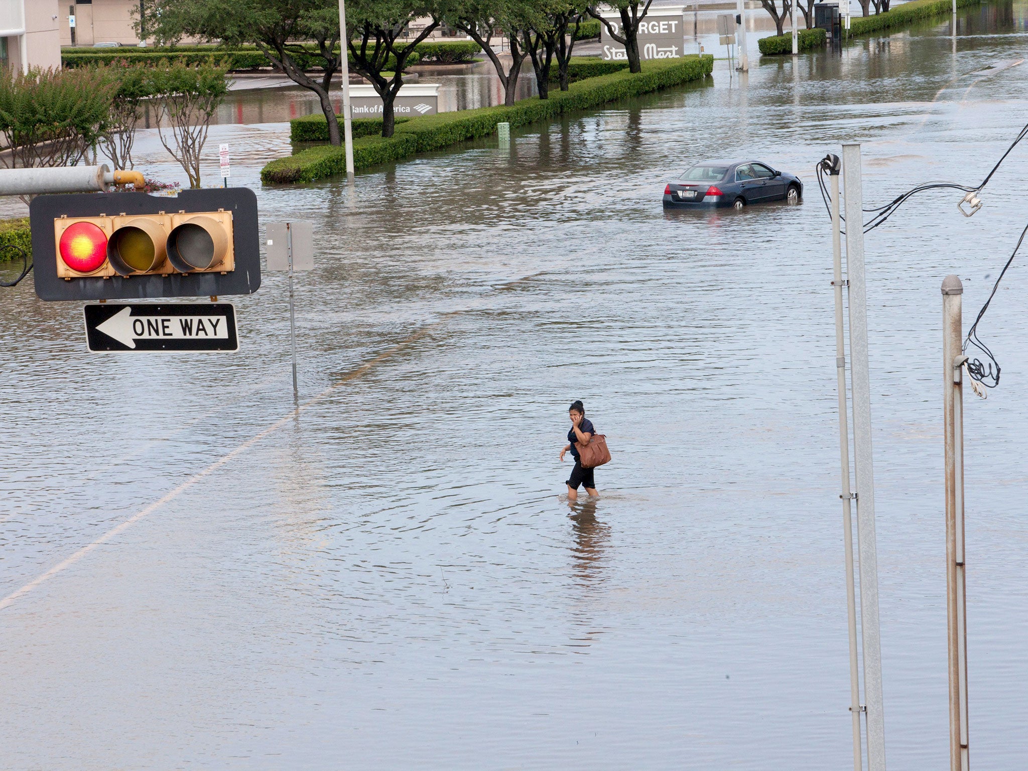 A woman walks in the flood waters in southwest Houston