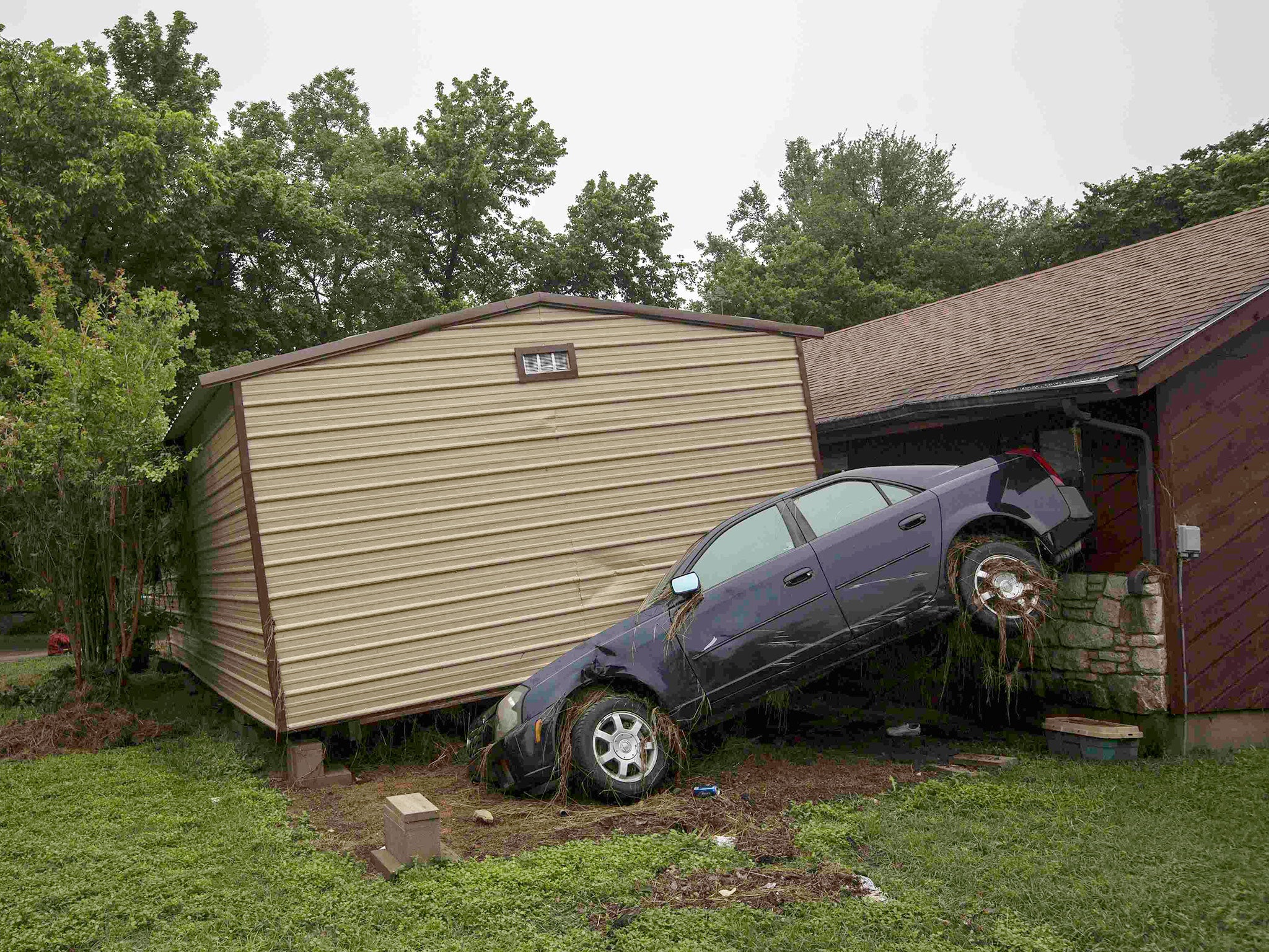 Flood damaged vehicles and debris are strewn across lawns throughout the length of Bogie Drive in San Marcos