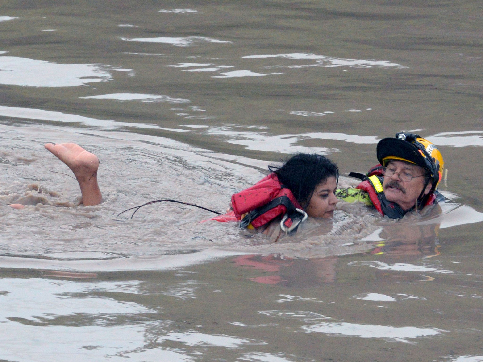 Firefighter Jay Horton rescues a woman from in flood waters in San Marcos