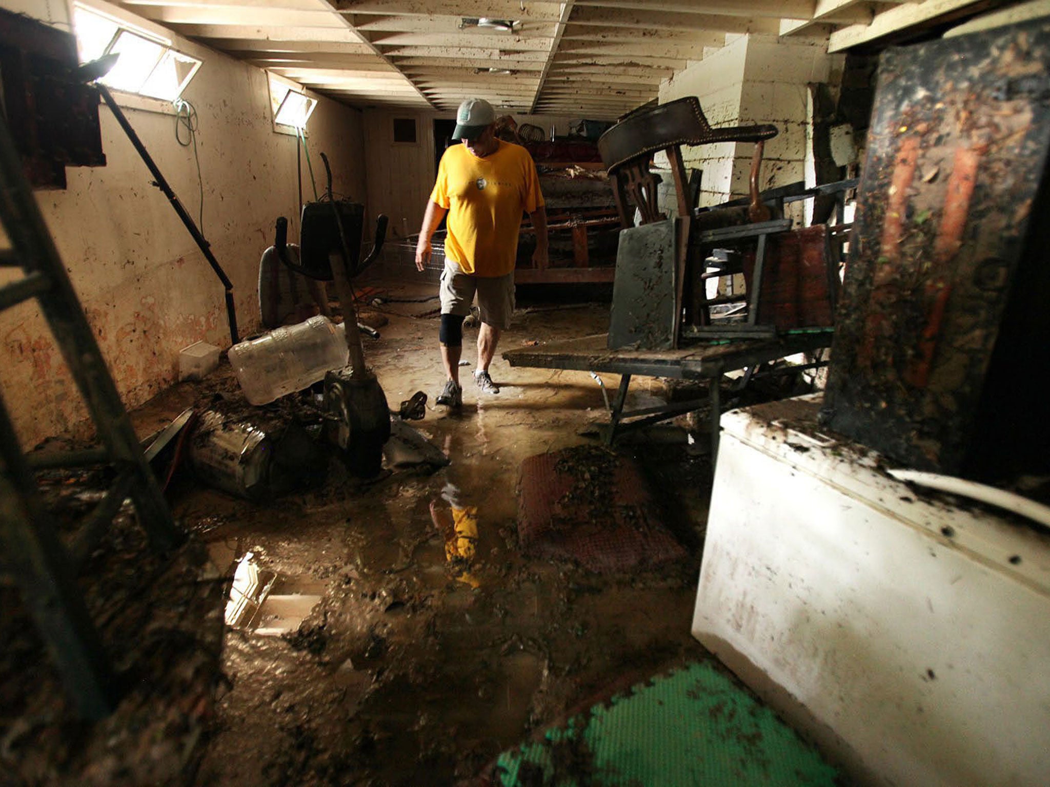 Gene McCarty works to clean up flood damage of his friends home in Wimberly