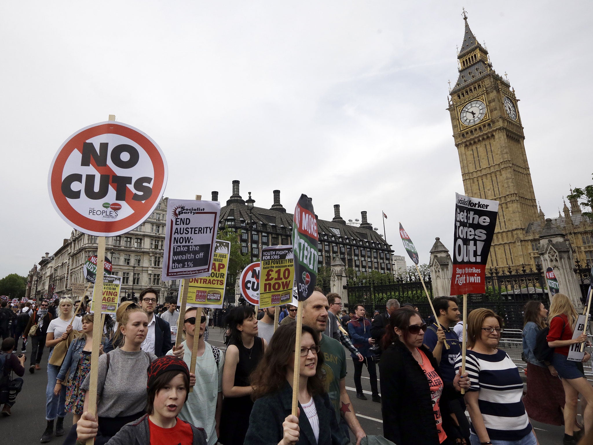 Protesters march with banners during an anti-austerity, anti-Conservative Party protest in May