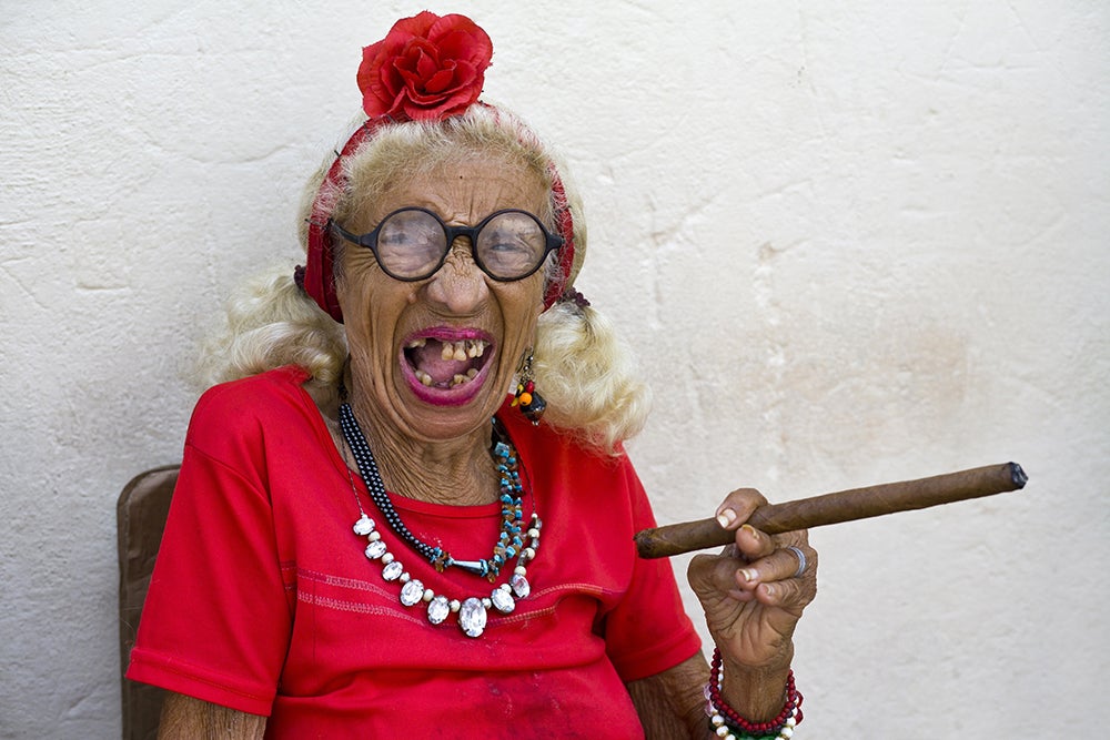 An old woman smoking a cigar in Cuba and loving life