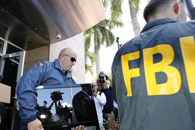 FBI agents carry boxes and computers from the headquarters of the football association Concacaf in Miami Beach, Florida, after a raid