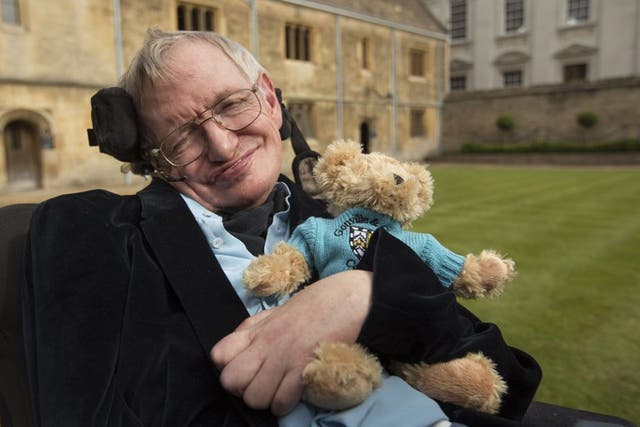 Stephen Hawking celebrating 50 years as a fellow of Gonville & Caius College, Cambridge, holding a Caius teddy bear.