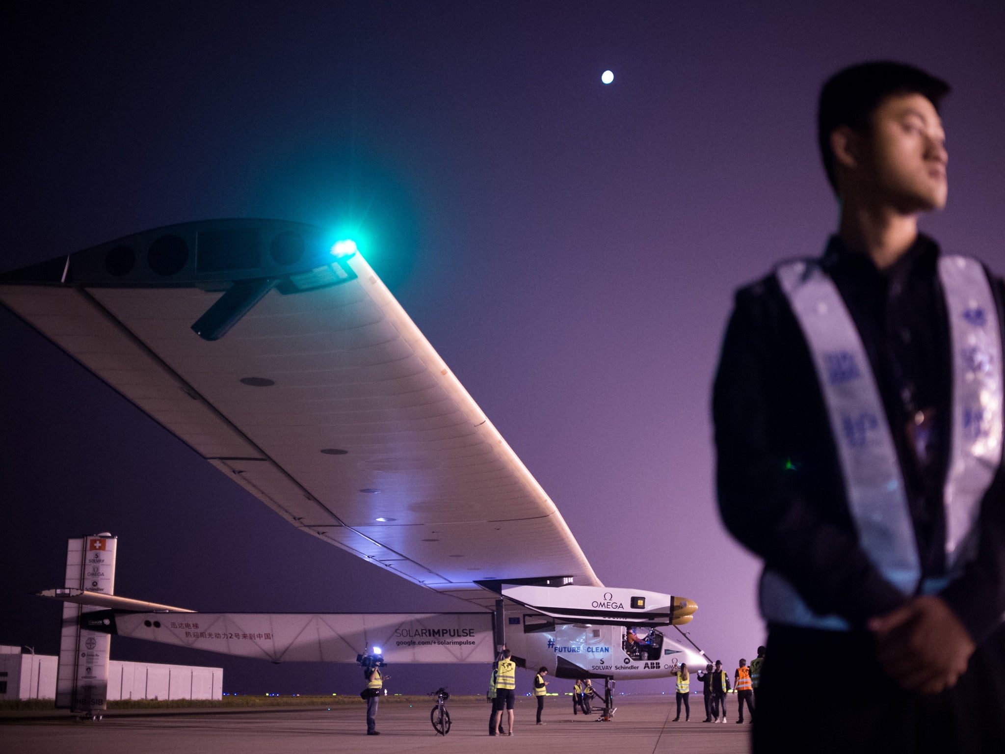 Chinese security staff member stands guard shortly before the Swiss-made solar-powered plane Solar Impluse 2 takes off from Nanjing's Lukou International Airport in Nanjing, in China's eastern Jiangsu province, early on May 31, 2015