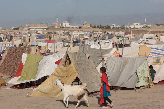 An Afghan girl walks among the multiplying tents at a refugee camp in Kunduz province, north of Kabul