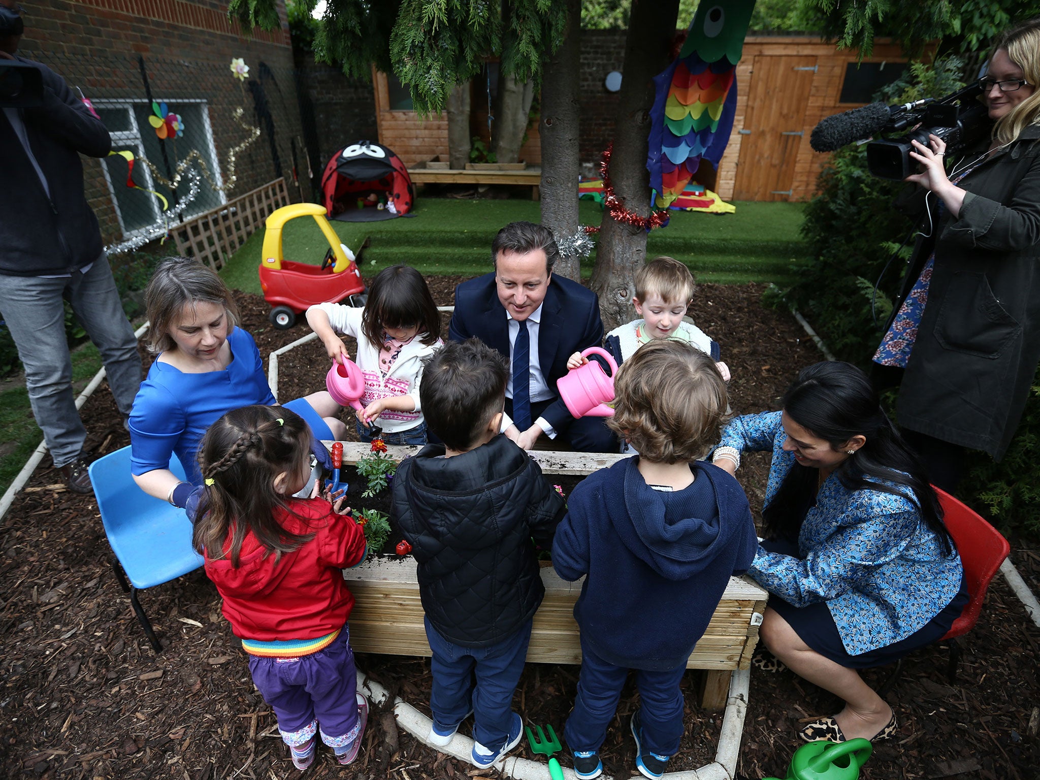 David Cameron plants flowers with children during a visit to a nursery. The new Childcare Bill will see childcare allowances double for parents with a household income of less than £150,000