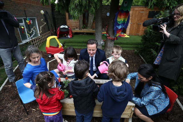 David Cameron plants flowers with children during a visit to a nursery. The new Childcare Bill will see childcare allowances double for parents with a household income of less than £150,000 