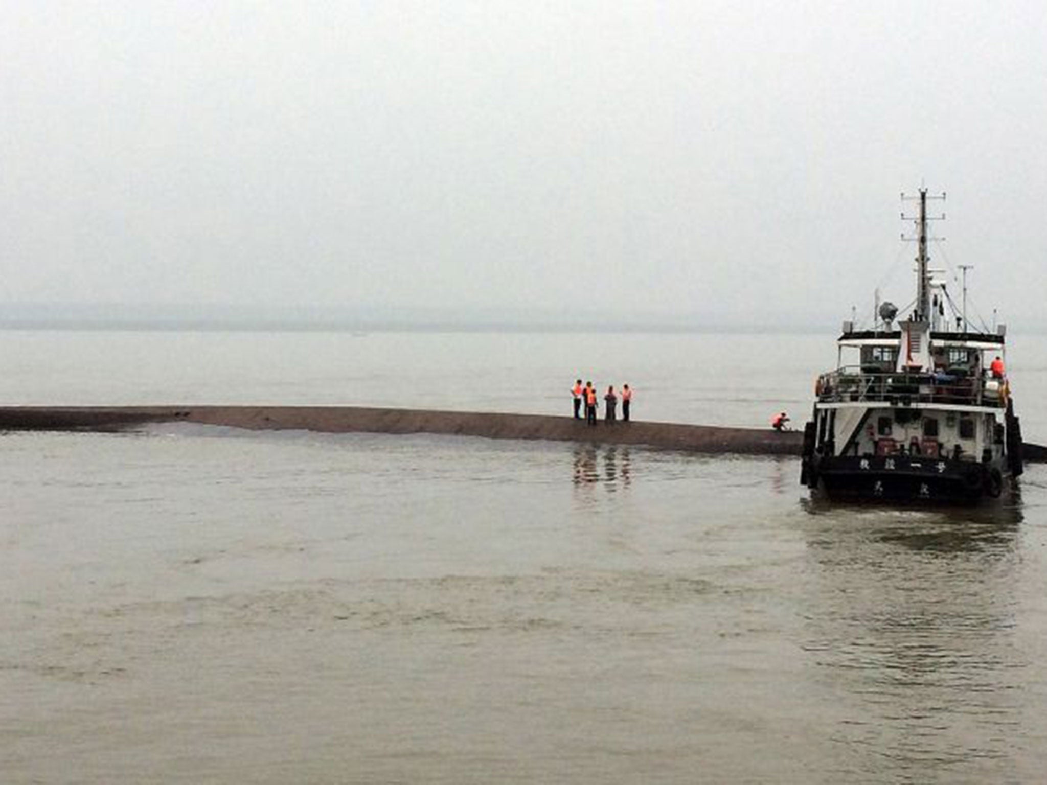 A Chinese rescue boat is seen alongside a capsized passenger ship carrying more than 450 people which sunk in the Yangtze river, triggering a rescue effort hampered by strong winds and heavy rain