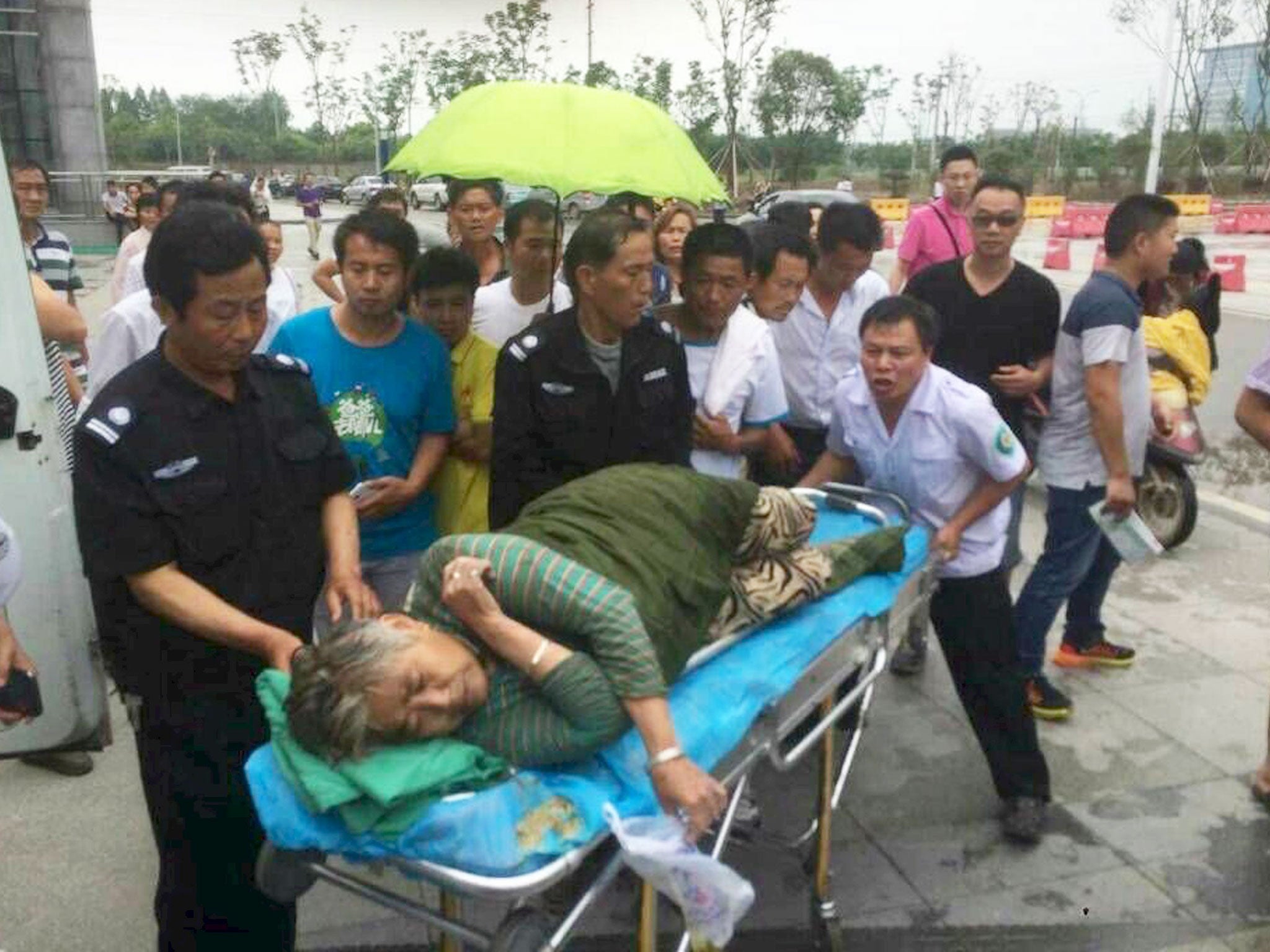 A woman is helped as she is sent to hospital after being pulled out by a diver from the sunken ship in Jianli, Hubei province