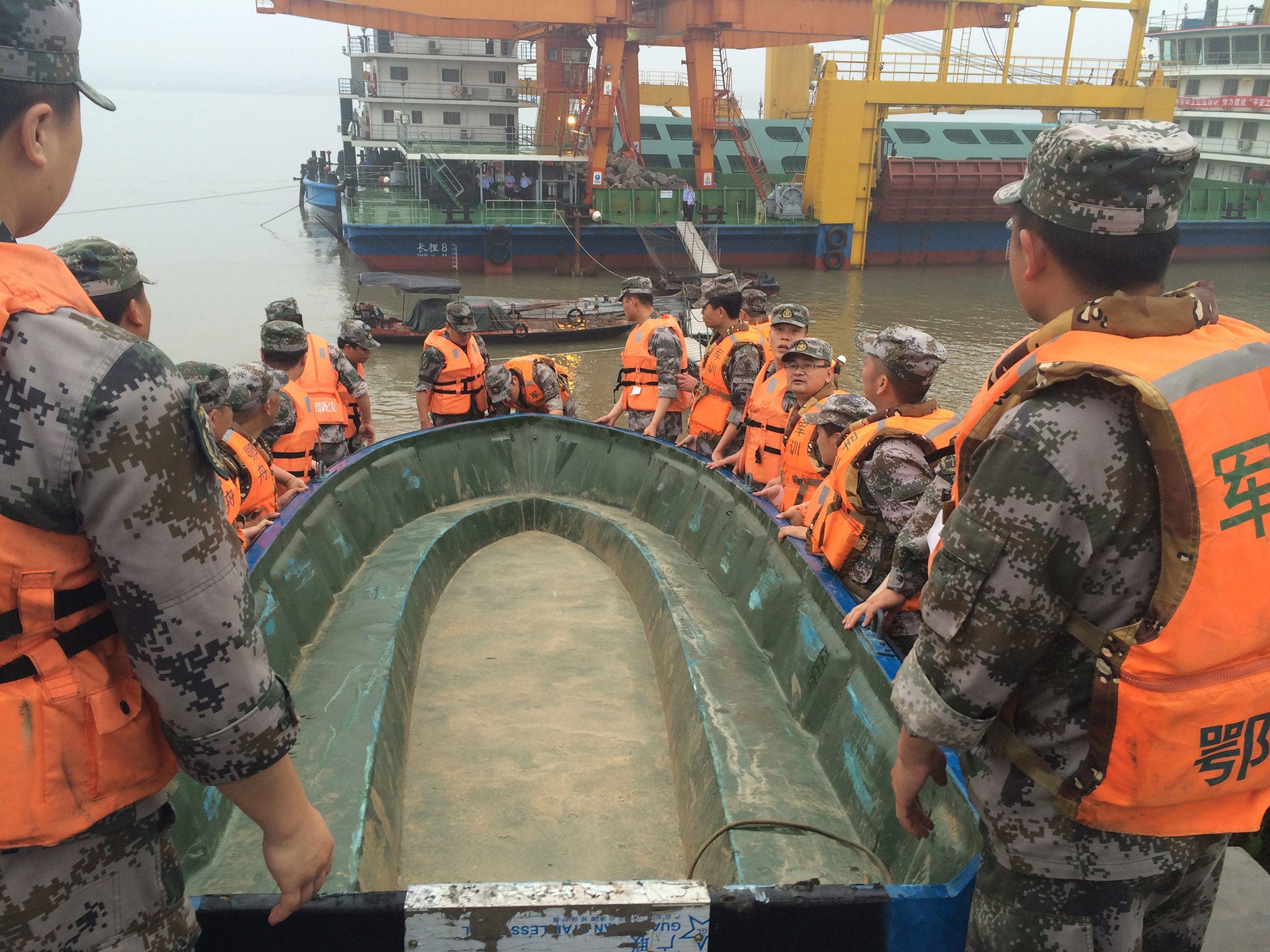Rescue workers carry a boat as they conduct a search