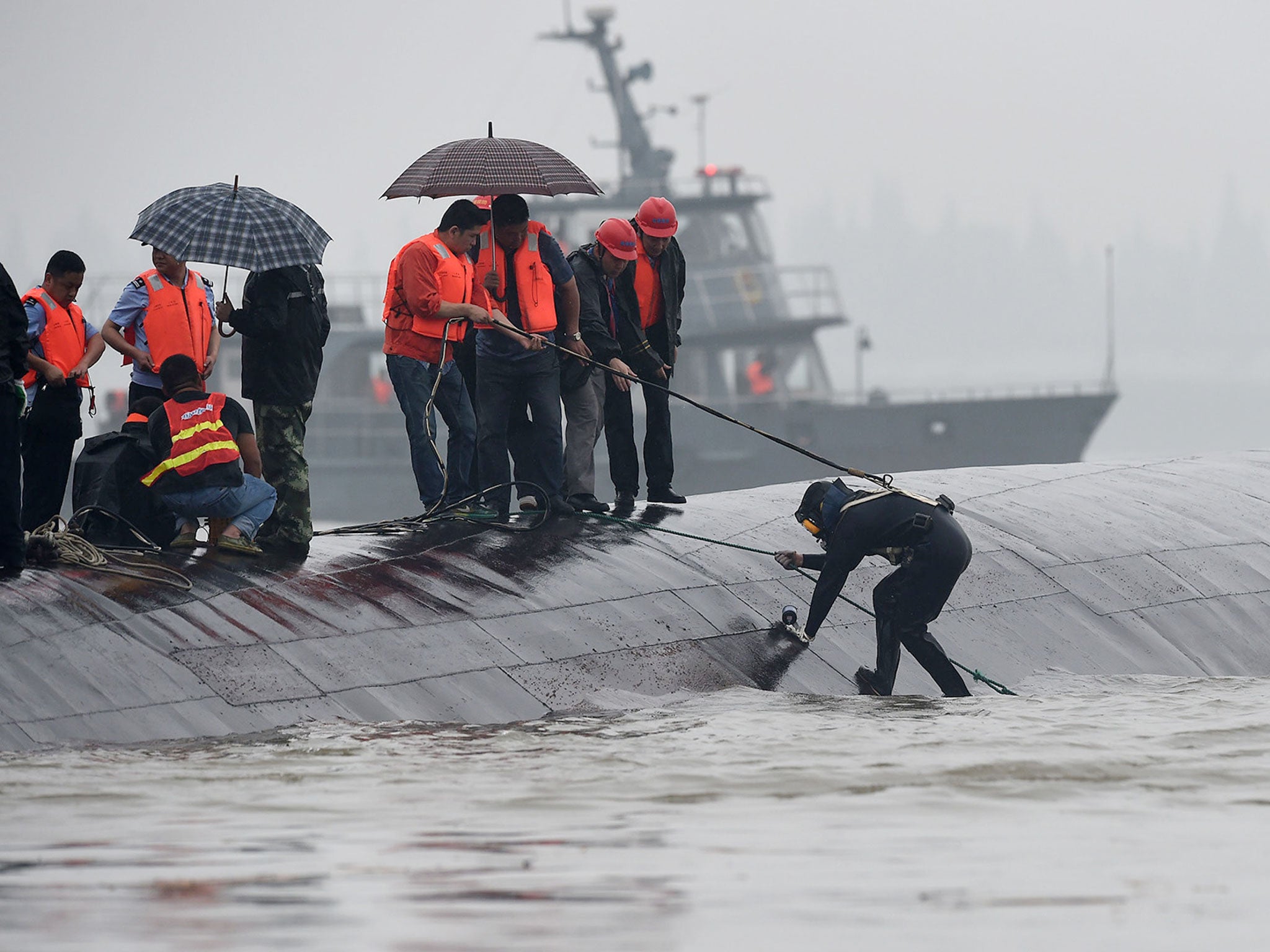 Rescuers work on the overturned passenger ship, which capsizes on Yangtze River, Hubei Province