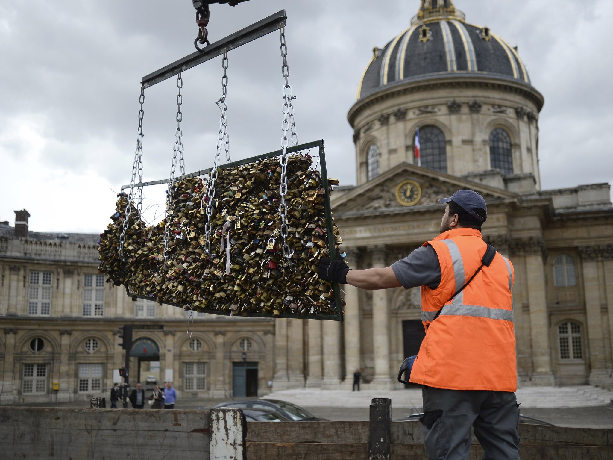 City worker removes 'love locks' at Pont des Arts bridge