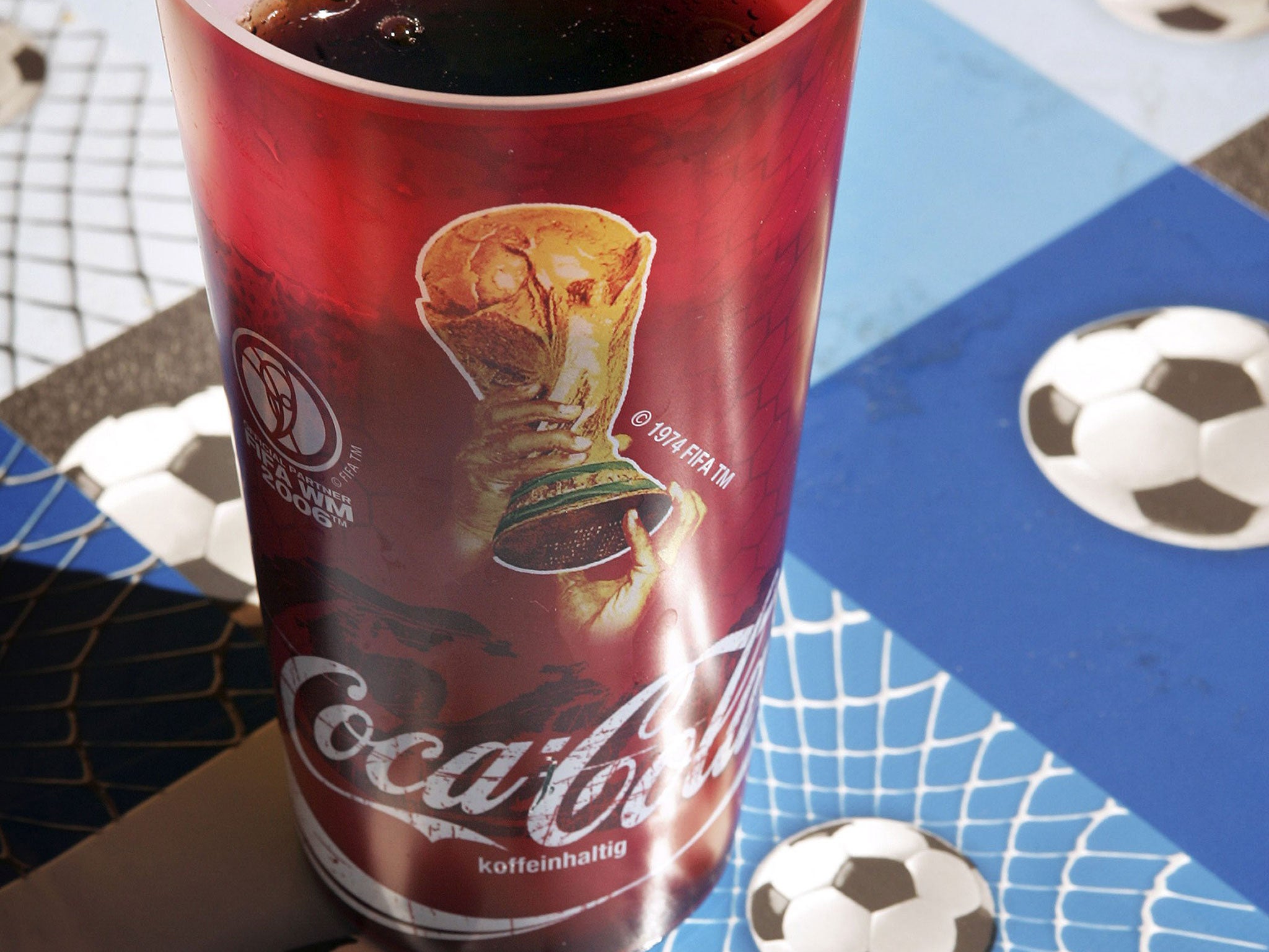 A World Cup branded Coca-Cola drink sits on a football patterned table cloth on June 11, 2006 in Frankfurt, Germany. On the third day of the FIFA World Cup three matches will take place in Leipzig, Nuremberg and Cologne.