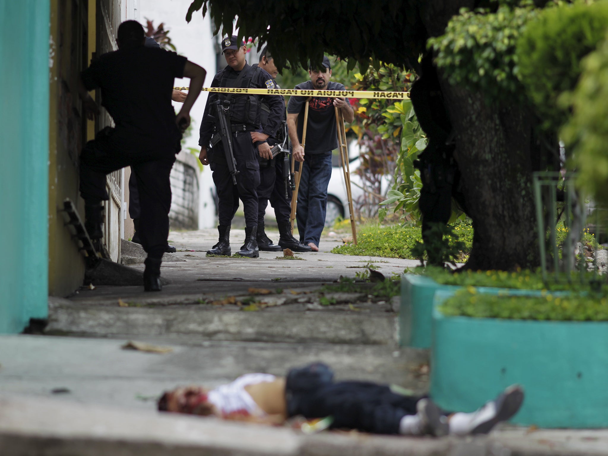 Police stand near body of Josue David Penalba Rivera, shot in San Salvador by suspected gang members