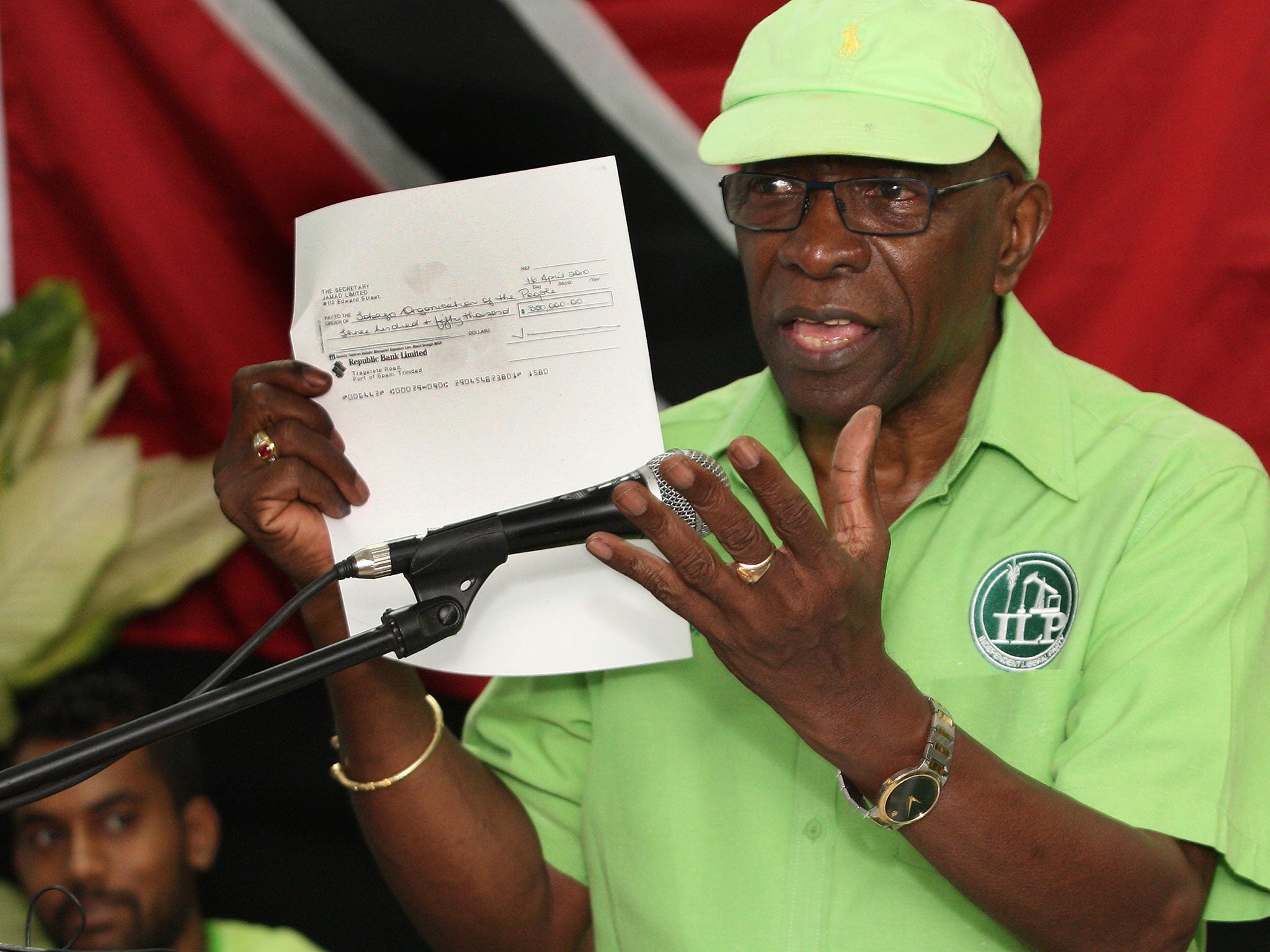 Former FIFA vice president Jack Warner hold a copy of a cheque while he speaks at a political rally in Marabella, Trinidad and Tobago, on Wednesday, 3 June 2015