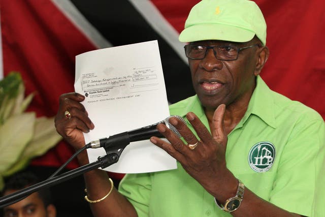 Former FIFA vice president Jack Warner hold a copy of a cheque while he speaks at a political rally in Marabella, Trinidad and Tobago, on Wednesday, 3 June 2015