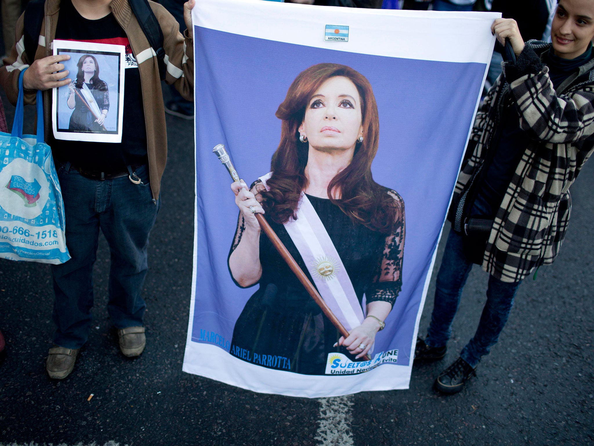 People hold a picture of President Cristina Fernandez at a demonstration against gender violence