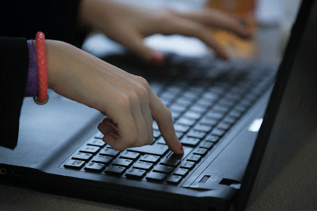 A pupil uses a laptop computer during an English lesson