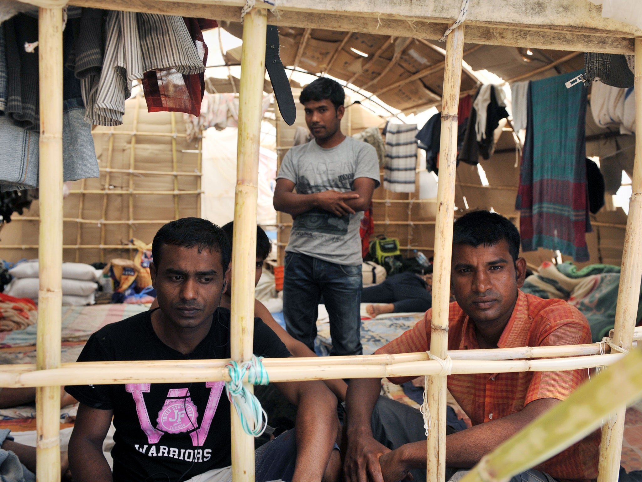 Migrant workers sit inside a makeshift camp in Manolada, circa 2013.