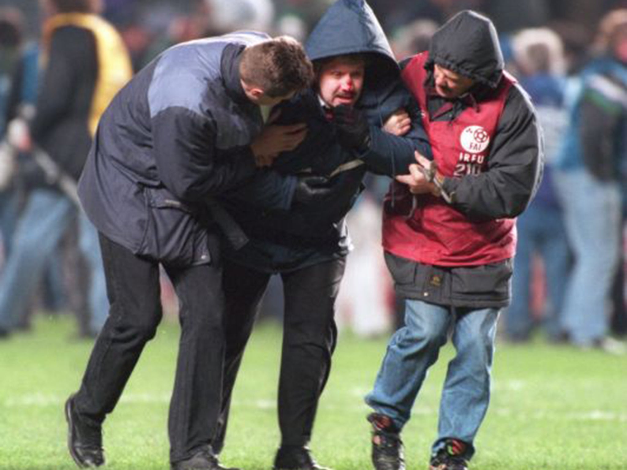 An injured Irish fan is helped away from the conflict