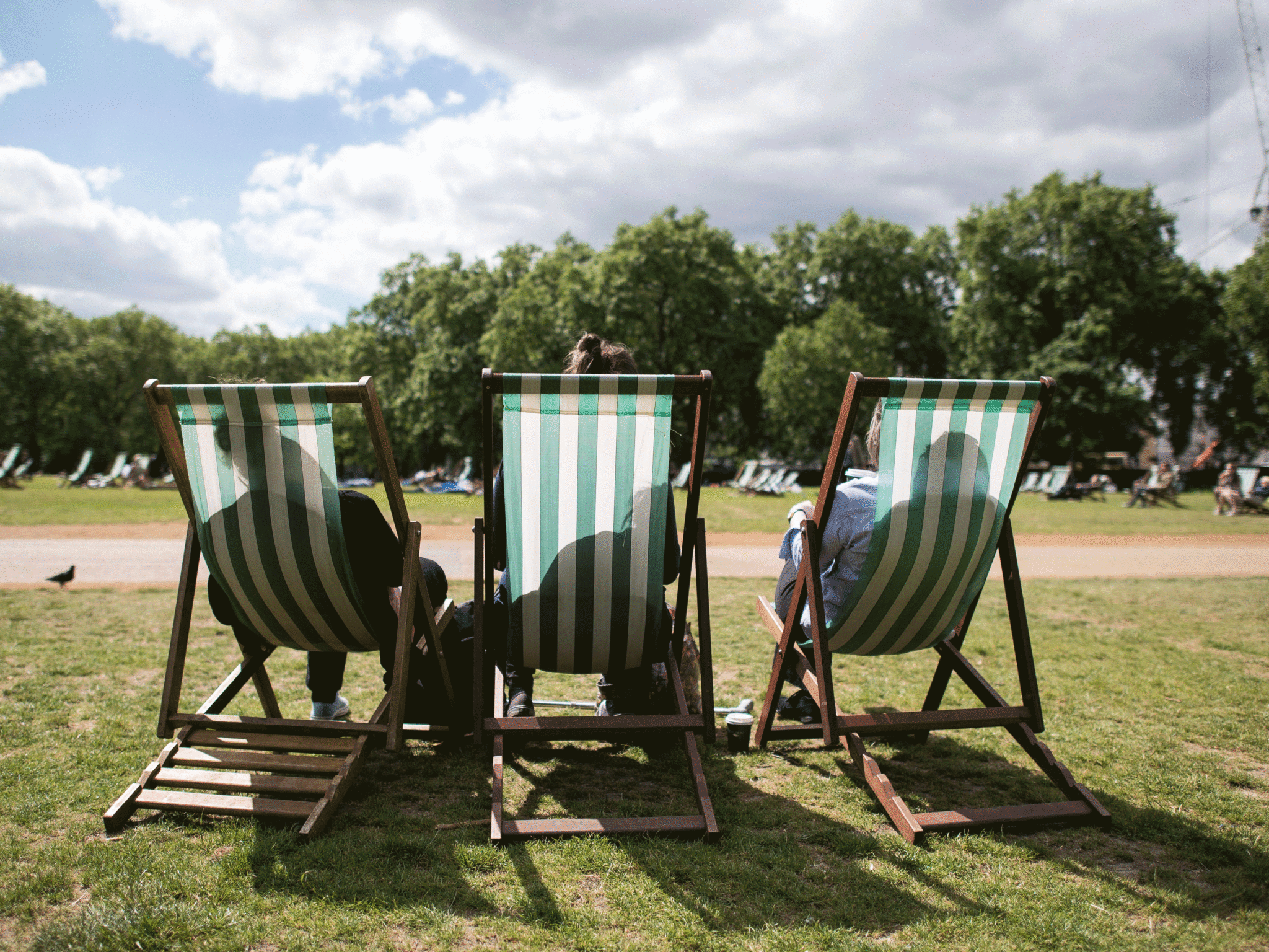 People sit in deckchairs as they enjoy the sun in Green Park, central London on June 3, 2015
