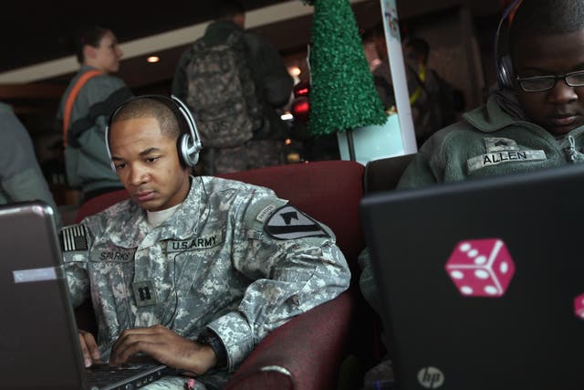 U.S. Army Captain Bishop Sparks shops for a car online as he sits in a Starbucks coffee shop while continuing to wait to leave Kuwait and head home after exiting from Iraq on December 11, 2011