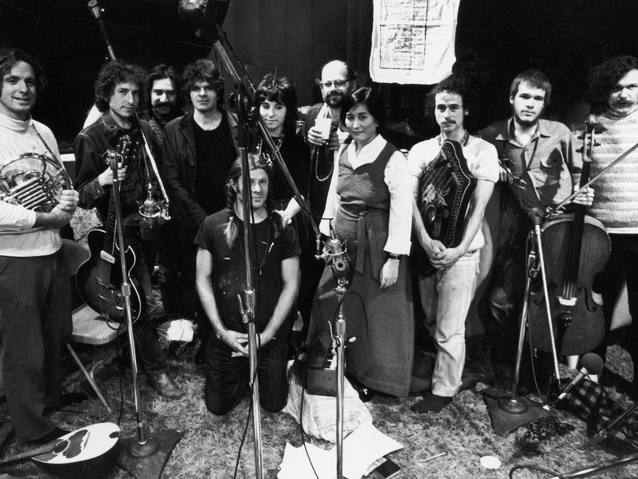 Posing for a group portrait at a recording session, from left, David Amram, Bob Dylan, Happy Traum, Gregory Corso (1930 - 2001), Peter Orlovsky (kneeling, fore), Denise Mercedes, Allen Ginsberg (1926 - 1997), Sadi Kazi, John Sholle, Arthur Russell, and Ed Sanders