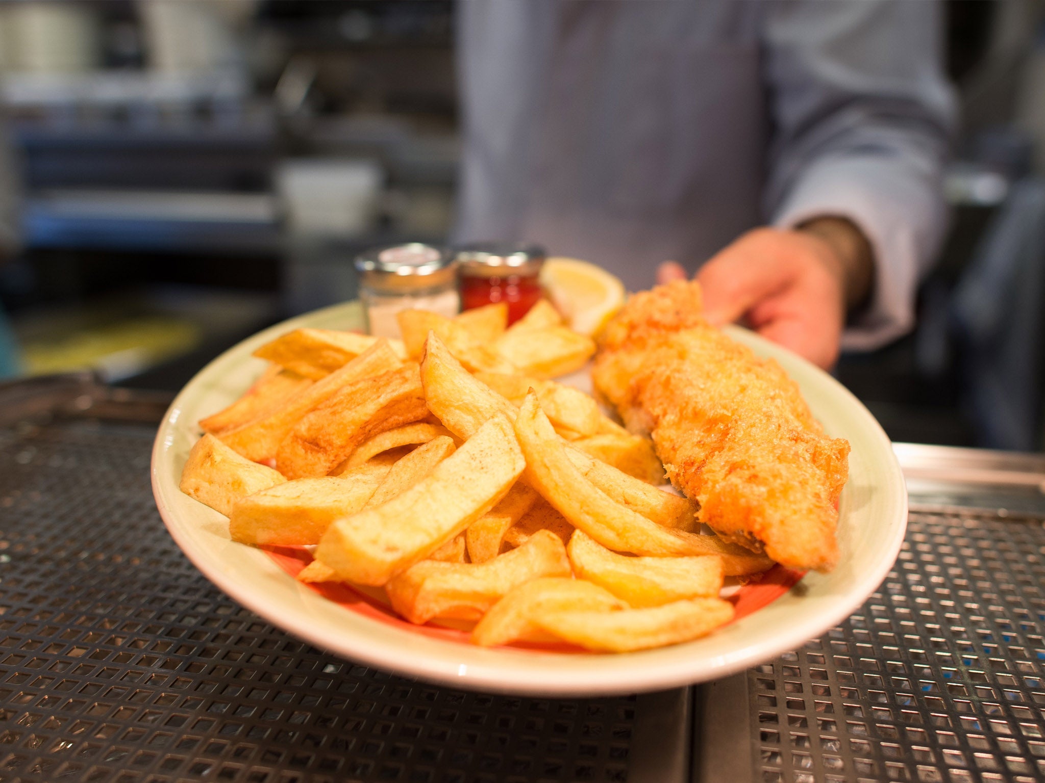 A chef poses with a plate of fish and chips at Poppies fish and chip restaurant in east London on 26 January 2015