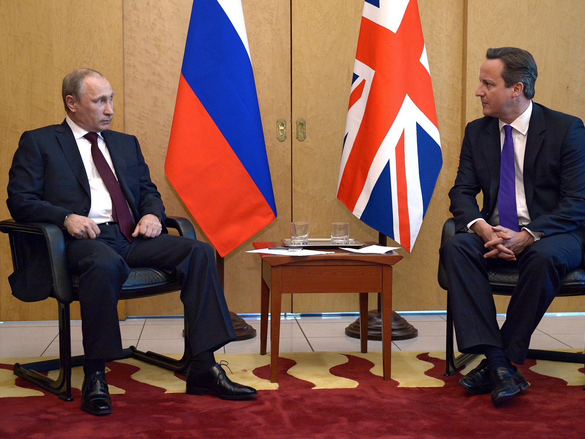 Russia's President Vladimir Putin (L) speaks with Britain's Prime Minister David Cameron (R) as they meet at Charles De Gaulle Airport in Paris on June 5, 2014