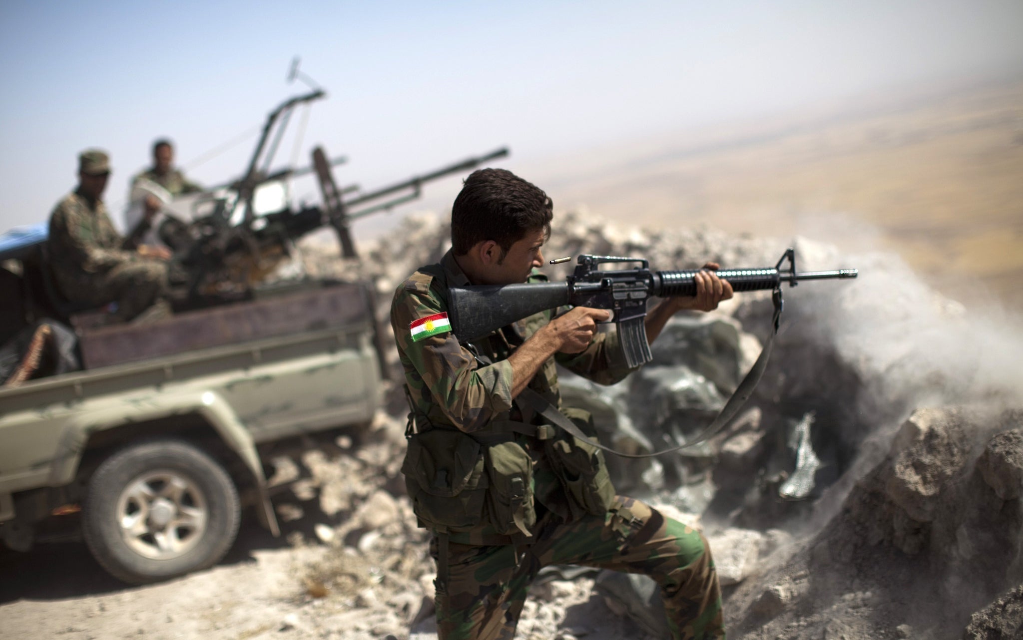 A Peshmerga fighter fires at an Isis position in Iraq. Kurdish officials claim that Isis has previously used chlorine gas against Peshmerga fighters.
