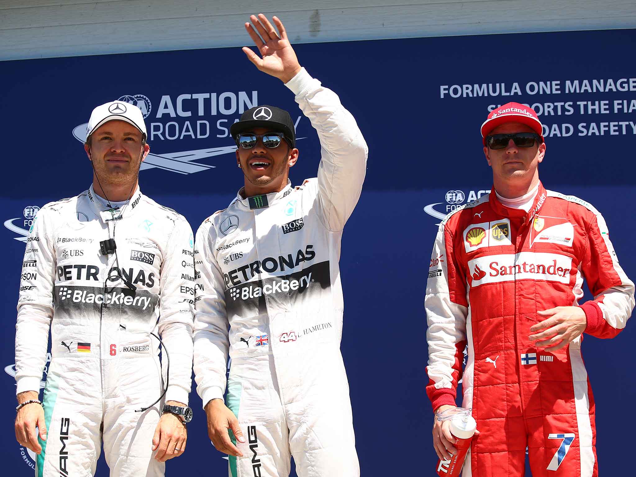 Lewis Hamilton celebrates pole position alongside Nico Rosberg (L) and Kimi Raikkonen (R)