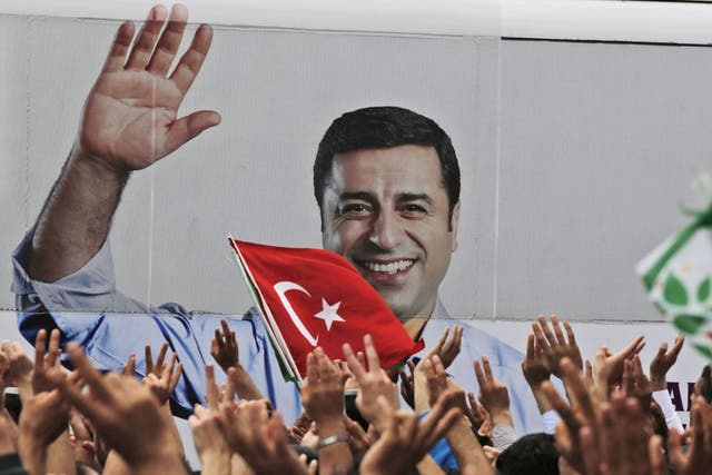 A bus carrying Selahattin Demirtas, his image on its side, drives off after a rally in Istanbul