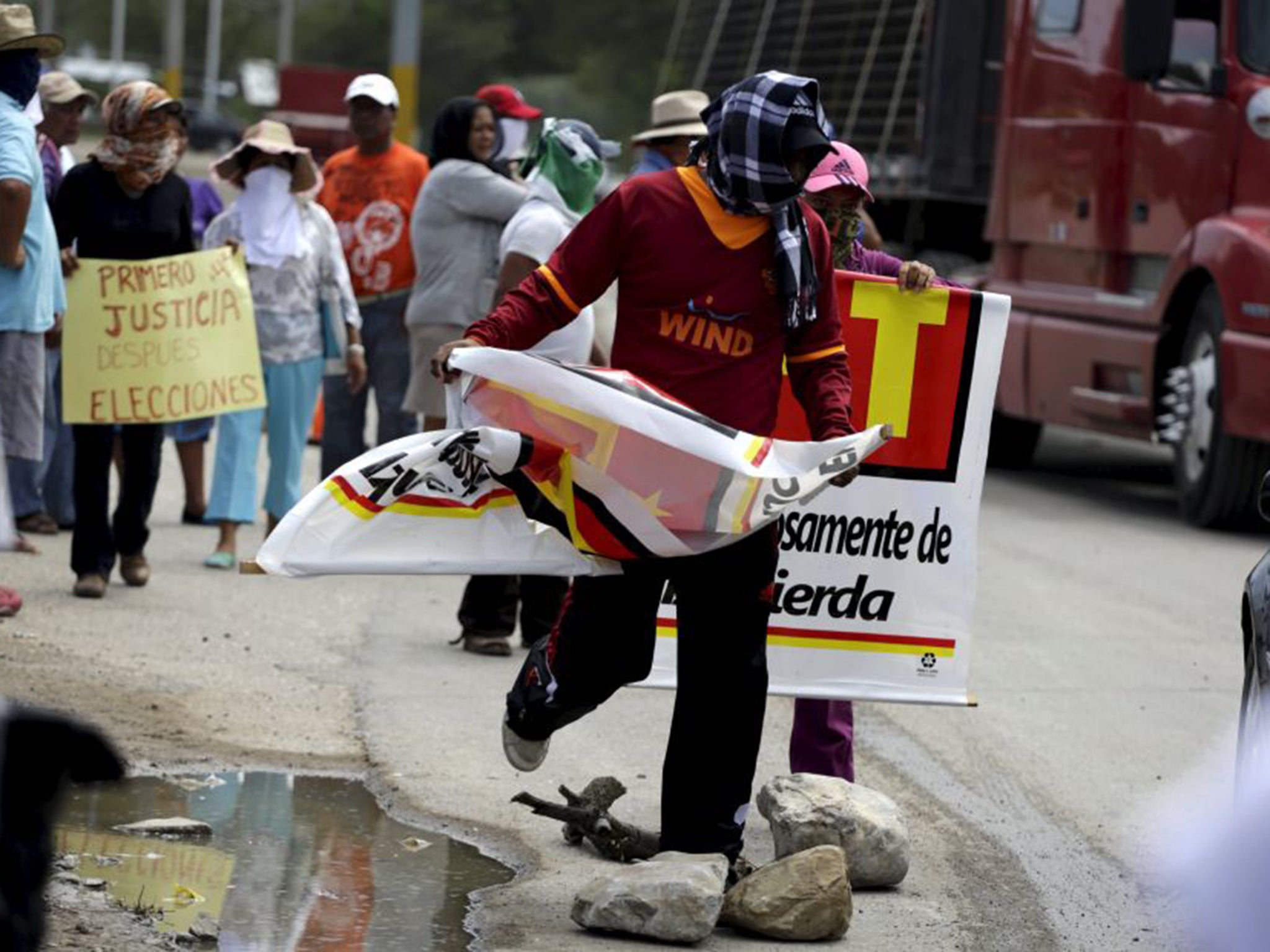 Masked men burning campaign materials in Guerrero. Parents and classmates of 43 trainee teachers who disappeared in the state last September have led a campaign to boycott the elections