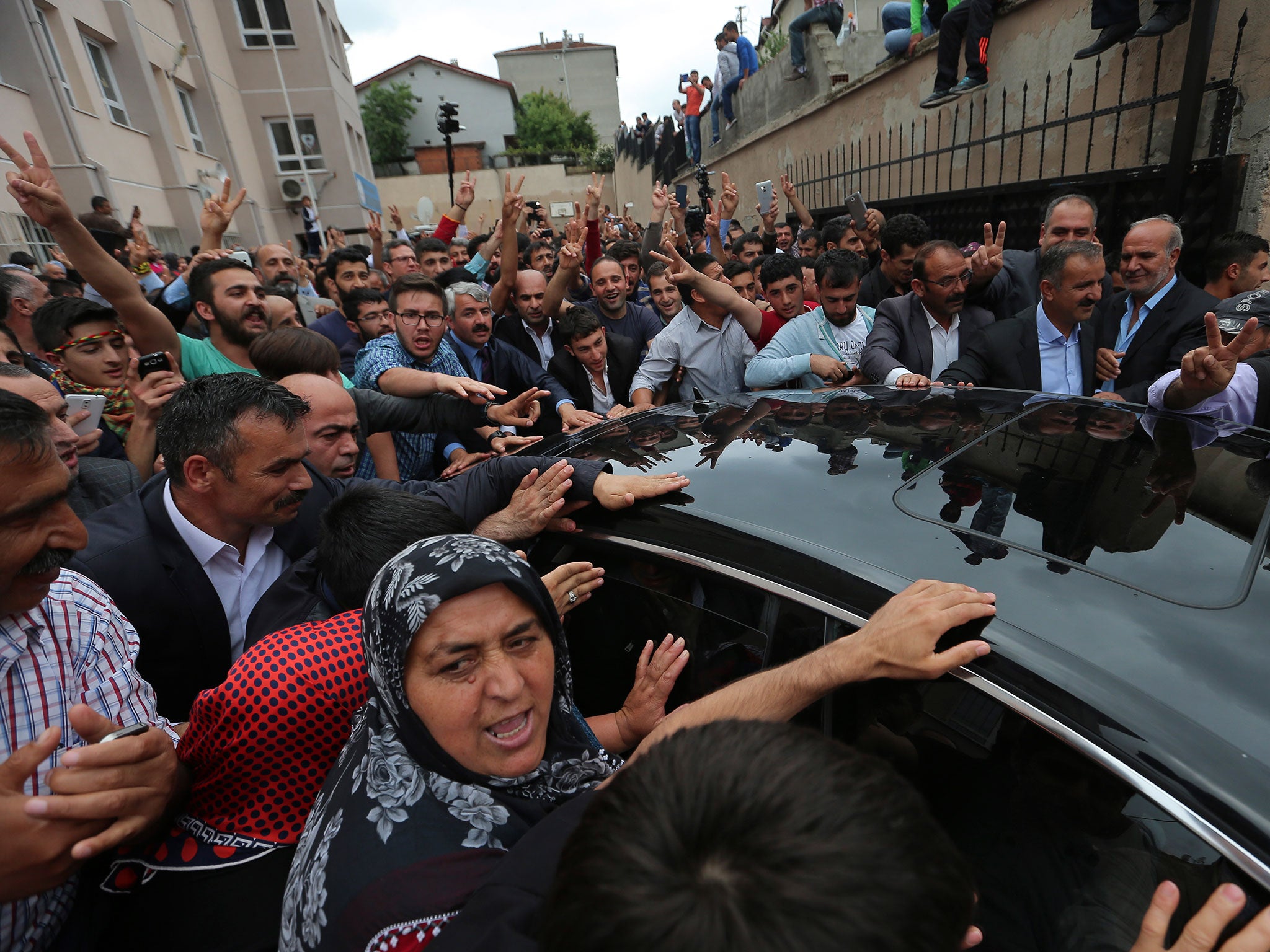 Supporters of Selahattin Demirtas of the pro-Kurdish People’s Democratic Party (HDP) gather round his car as he arrives to cast his vote