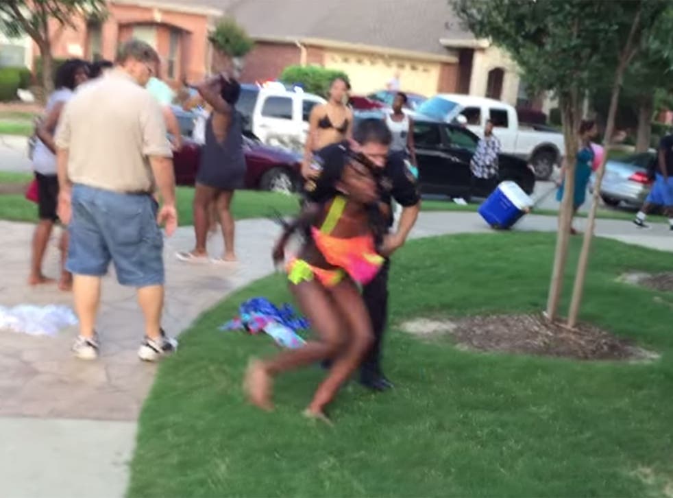 A Texas police officer has been placed on leave after video emerged of him throwing a 14-year-old African American girl to the ground, kneeling on her back and pointing his gun at teenagers who protested at her treatment