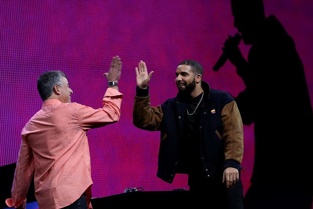 Apple's senior vice president of Internet Software and Services Eddy Cue (L) high fives with recording artist Drake during the Apple Music introduction at the Apple WWDC on June 8, 2015 in San Francisco, California