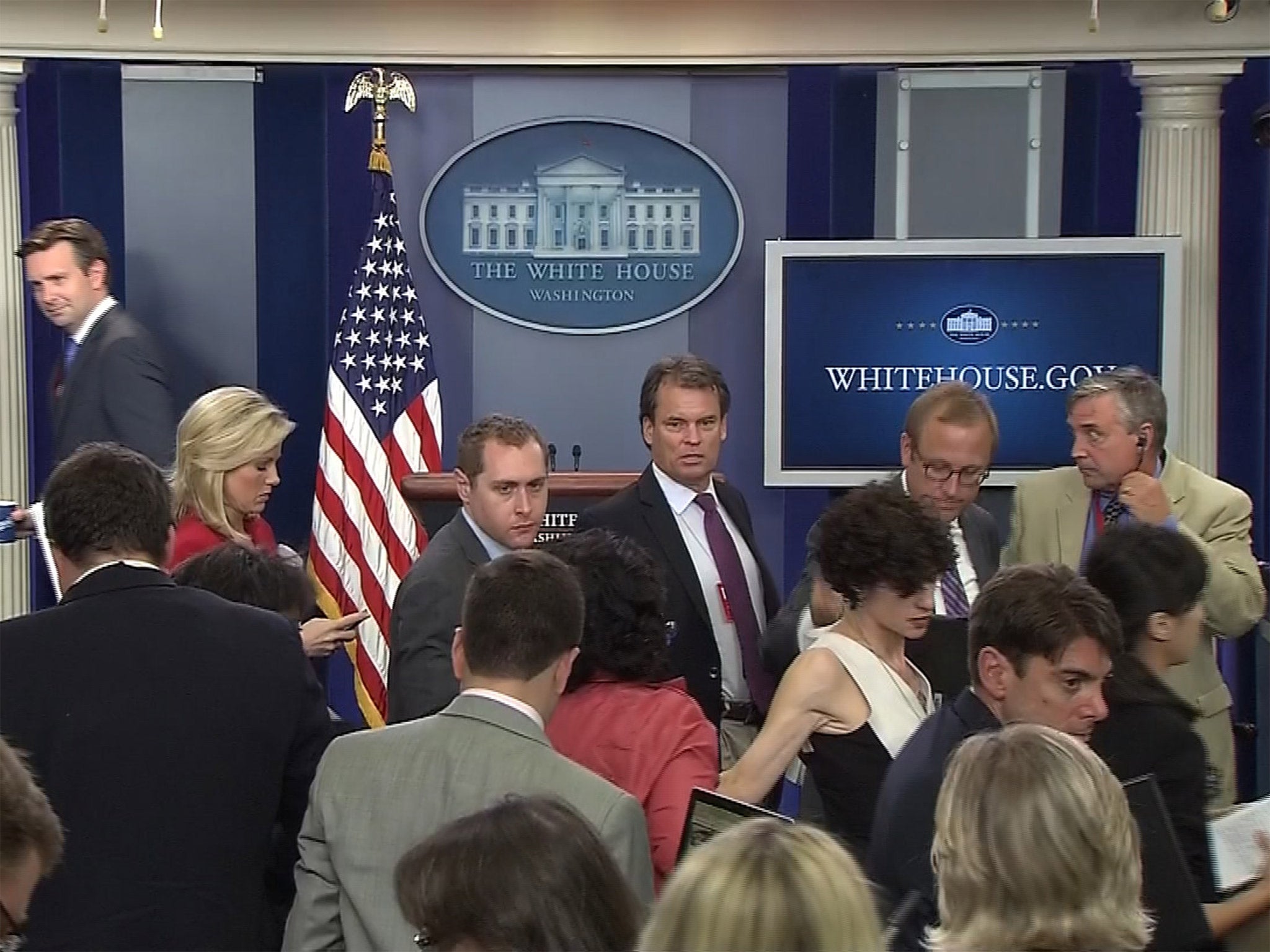White House Press Secretary John Earnest and correspondents depart the White House press briefing room