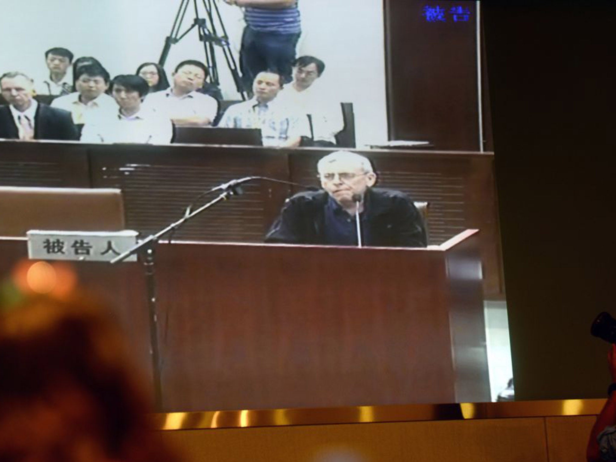 Journalists follow Peter Humphreys' trial in China on a television screen