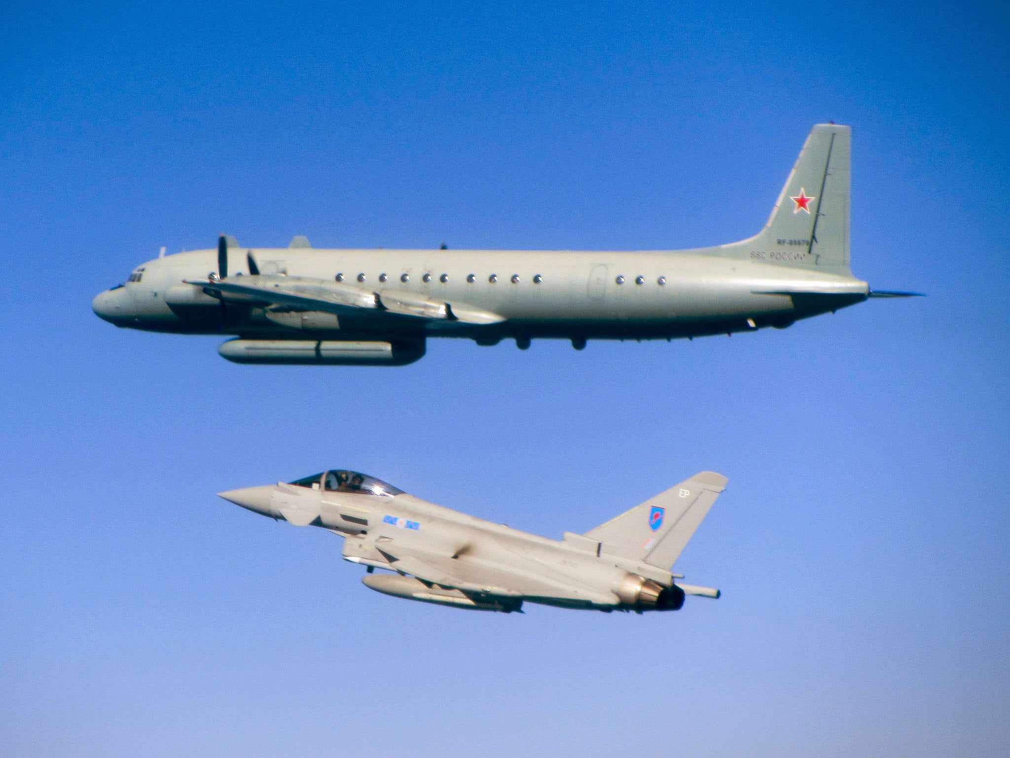 A handout photo provided by the MoD an RAF 'Typhoon' jet (bottom) accompanying a Russian Ilyushin Il-20M 'Coot' electronic intelligence gathering aircraft over the Baltic, 08 June 2015