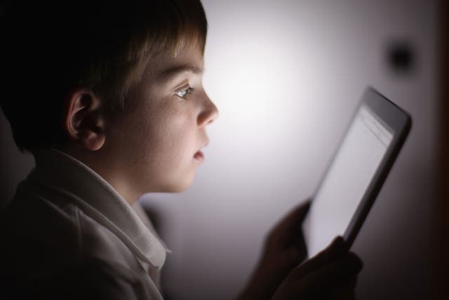 A boy uses an Apple Ipad tablet computer