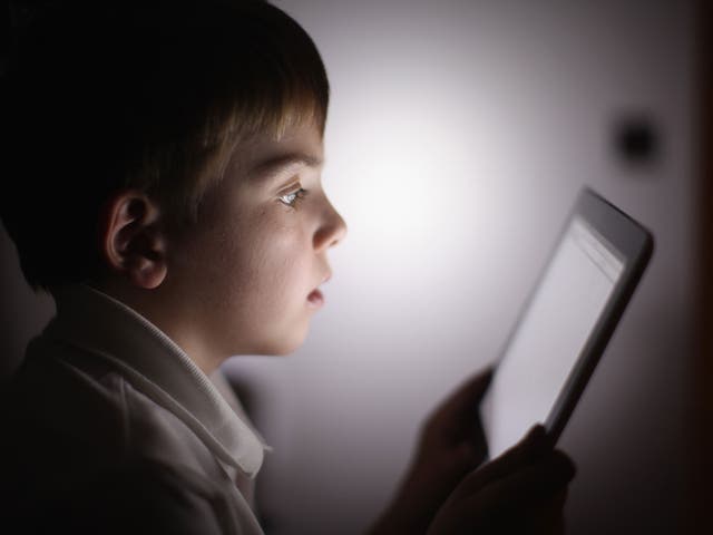 A boy uses an Apple Ipad tablet computer