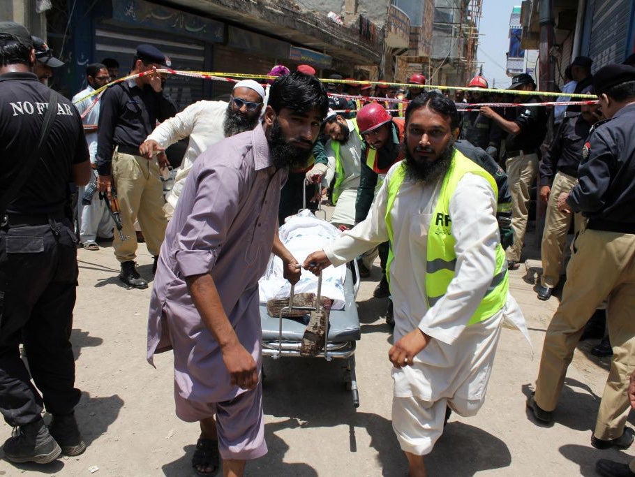 Rescue workers remove the two bodies of alleged suicide bombers from the site of the blast